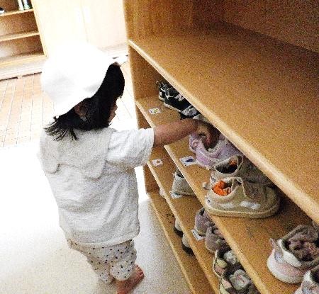 靴箱で靴を整理する子ども